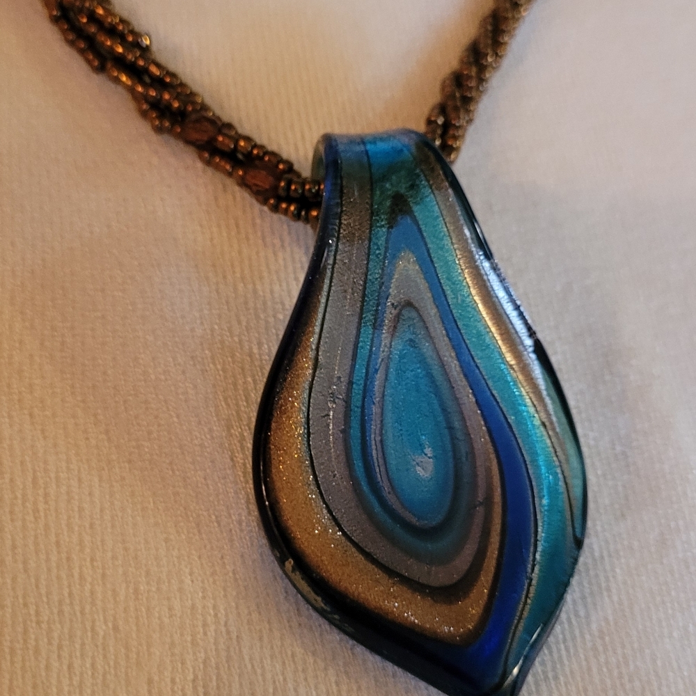 Hand-blown glass pendant Necklace strung with beads.